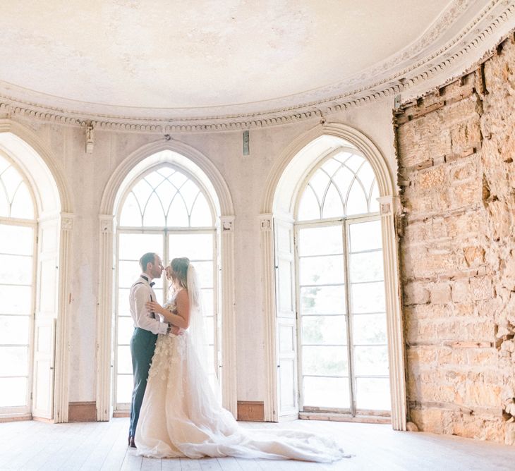 Bride in Strapless Liz Martinez Ballgown Wedding Dress with Embroidered Flowers | Cathedral Length Veil in Blush Soft Tulle | Groom in Navy Blue Suit with Burgundy Braces, Bow Tie and Brogues | Country Tipi Wedding with Macramé Arch and Hanging Flowers | Sarah-Jane Ethan Photography