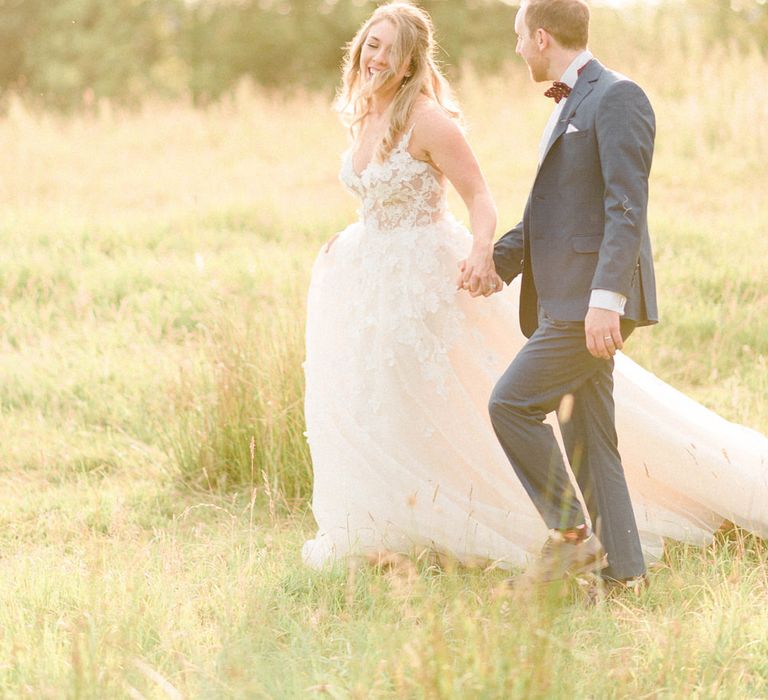 Bride in Strapless Liz Martinez Ballgown Wedding Dress with Embroidered Flowers | Groom in Navy Blue Suit with Burgundy Braces, Bow Tie and Brogues | Country Tipi Wedding with Macramé Arch and Hanging Flowers | Sarah-Jane Ethan Photography