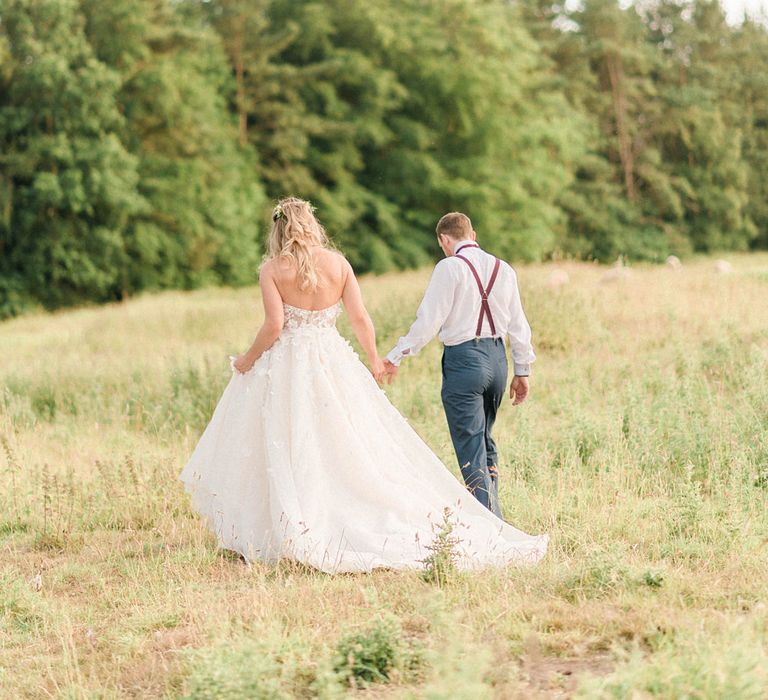 Bride in Strapless Liz Martinez Ballgown Wedding Dress with Embroidered Flowers | Groom in Navy Blue Suit with Burgundy Braces, Bow Tie and Brogues | Country Tipi Wedding with Macramé Arch and Hanging Flowers | Sarah-Jane Ethan Photography