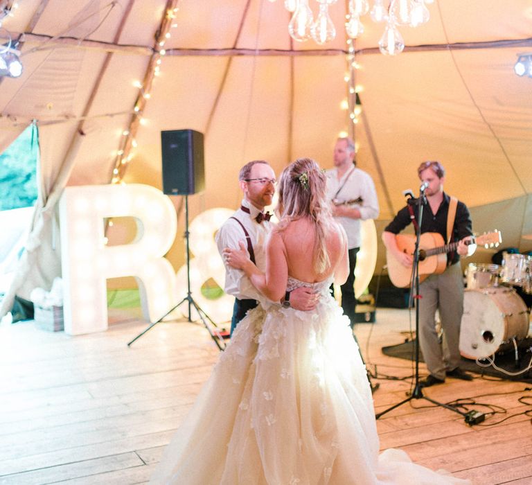 First Dance | Bride in Strapless Liz Martinez Ballgown Wedding Dress with Embroidered Flowers | Groom in Navy Blue Suit with Burgundy Braces, Bow Tie and Brogues | Country Tipi Wedding with Macramé Arch and Hanging Flowers | Sarah-Jane Ethan Photography