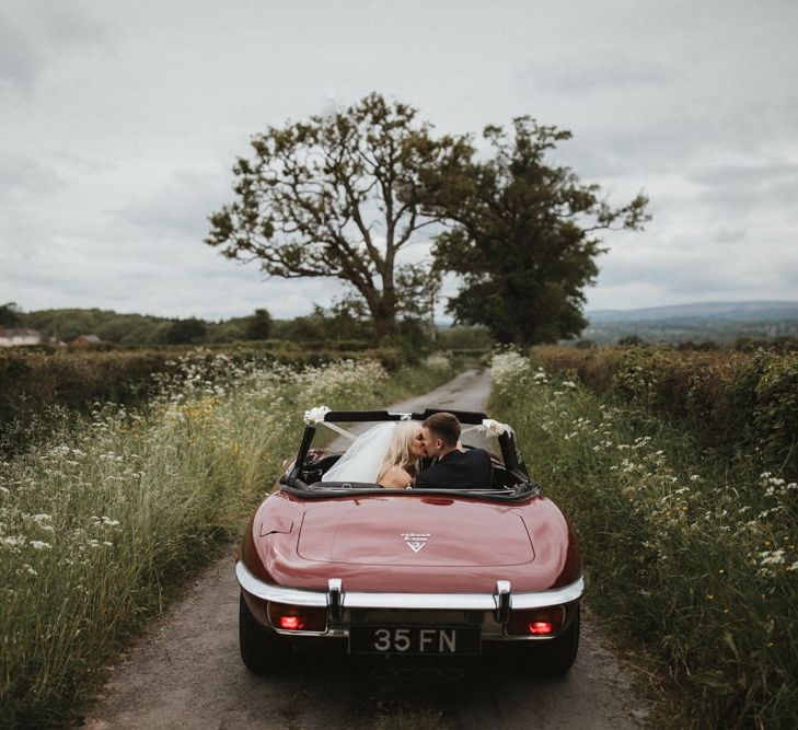 Bride and Groom In Red Vintage Car