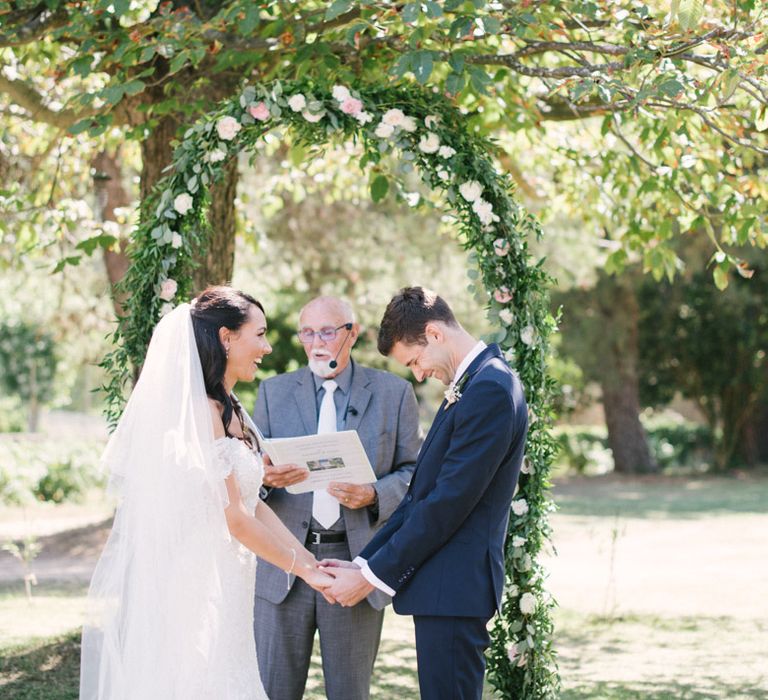 Bride and Groom Holding Hands During the Outdoor Wedding Ceremony