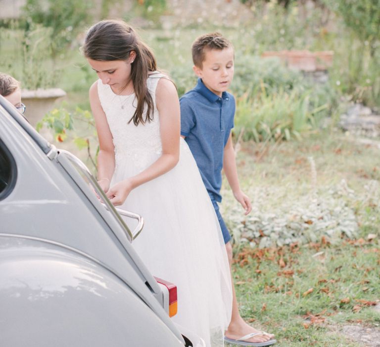 Flower Girl Tying Tin Cans to The Wedding Car