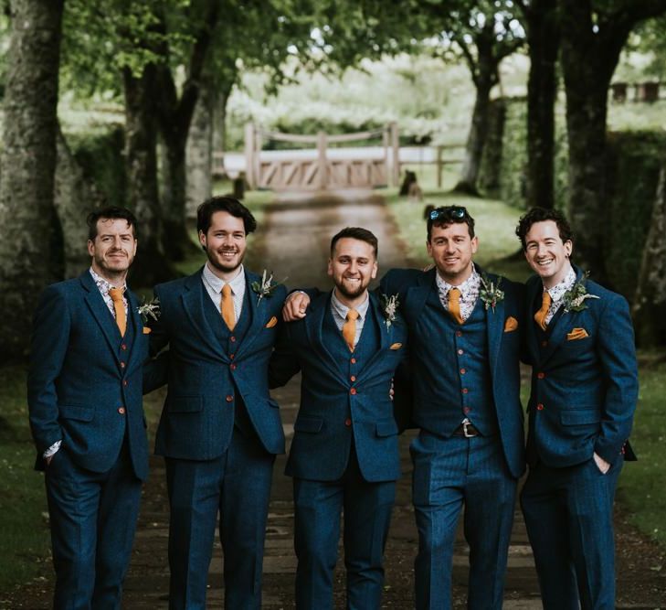 Groom and groomsmen in matching suits with orange ties