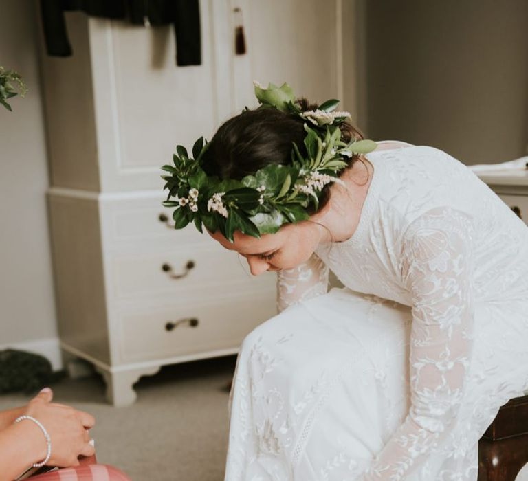 Bride slips shoes on in Savannah Miller wedding dress