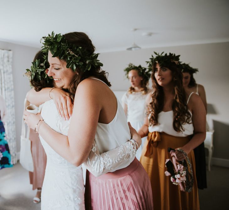 Bridesmaid hugs bride during preparations