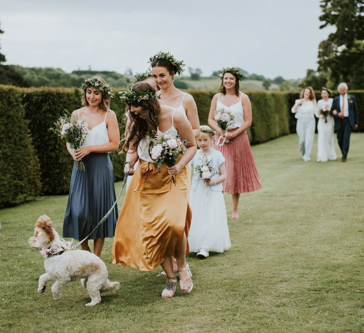 Bridal party and pet dog on their way to outdoor ceremony