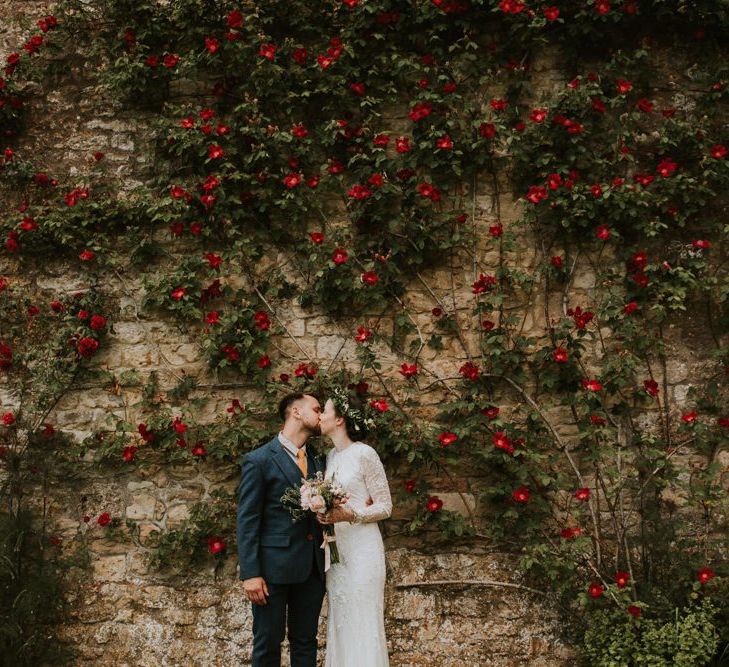 Bride in Savannah Miller wedding dress kisses groom in woolen suit