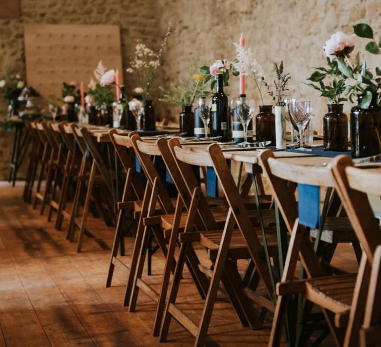 Wedding table decor with flower stems in glass bottles