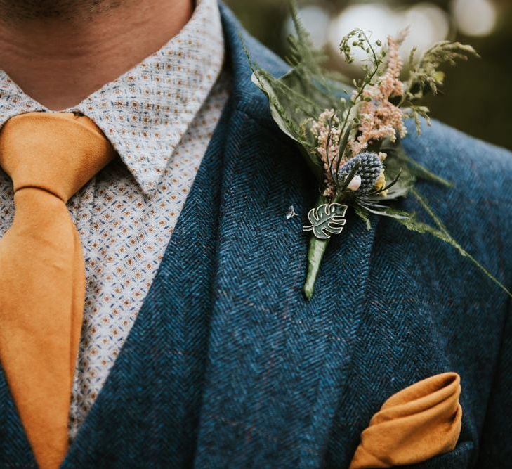 Groom in wooden suit with orange tie and pocket square