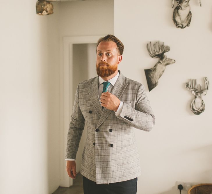 Groom in check suit for rustic wedding with macrame table runner