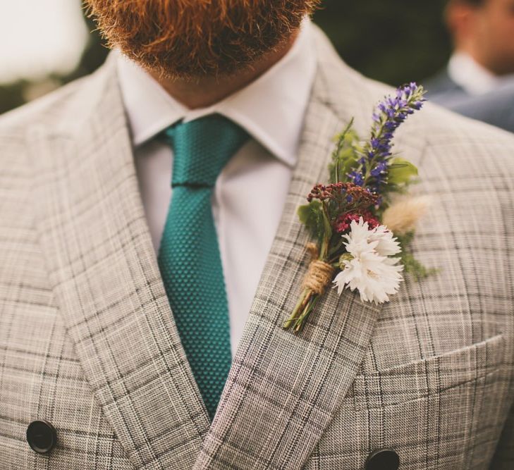 Floral buttonhole, check dinner jacket and green tie for groom