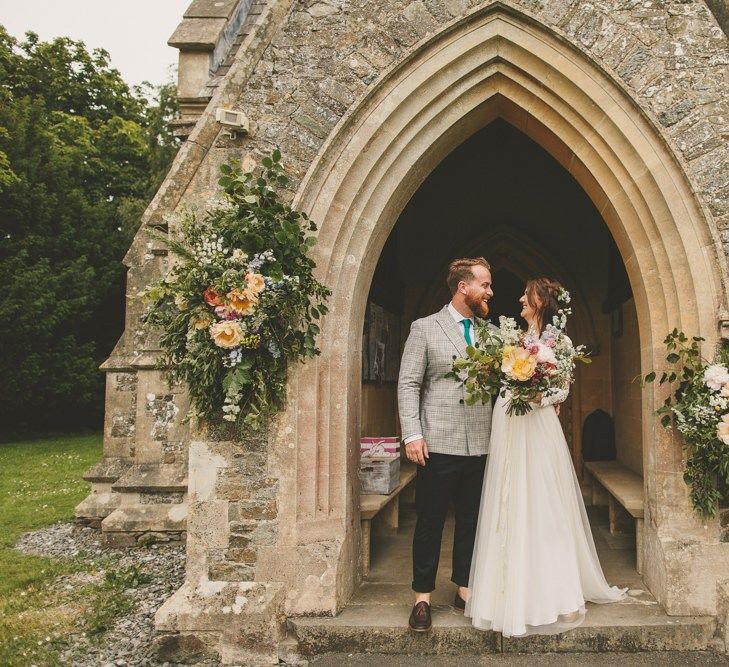 Bride and groom at rustic wedding with flowers and macrame table runner