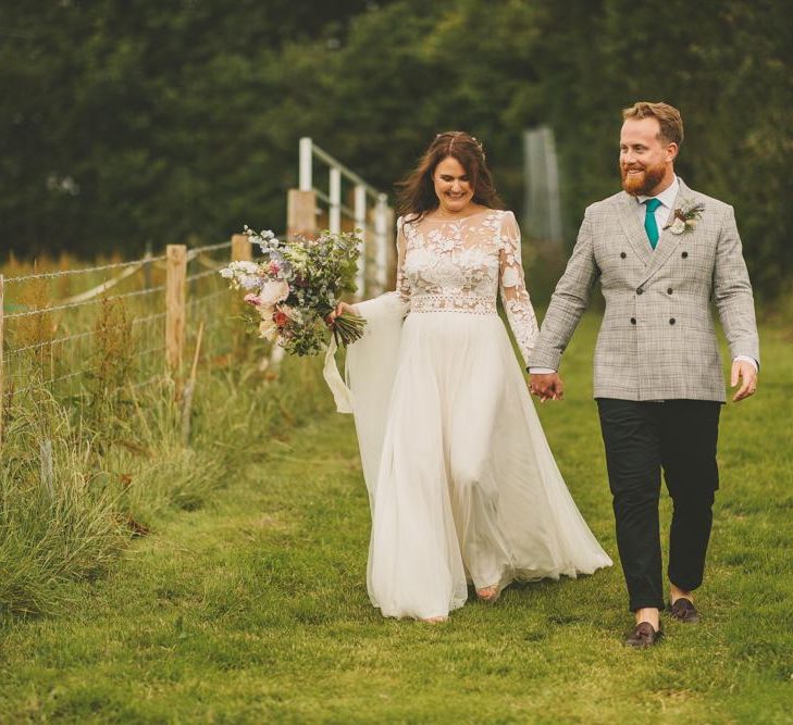 Bride and groom walk to reception with rustic decor and macrame table runner