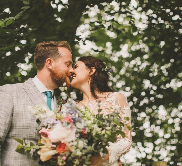 Bride and groom at rustic wedding with bouquet and macrame table runner