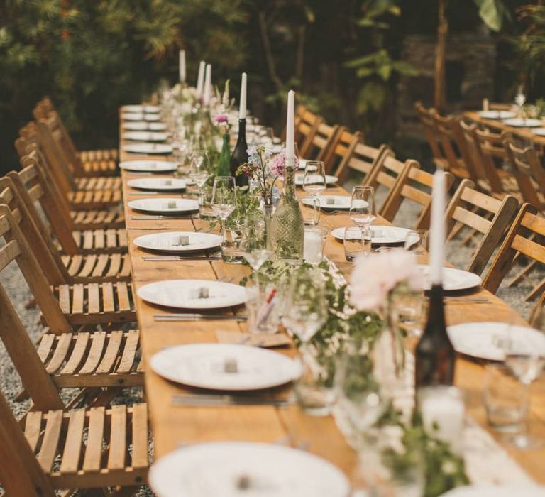 Glass bottle candle holders with foliage and macrame table runner