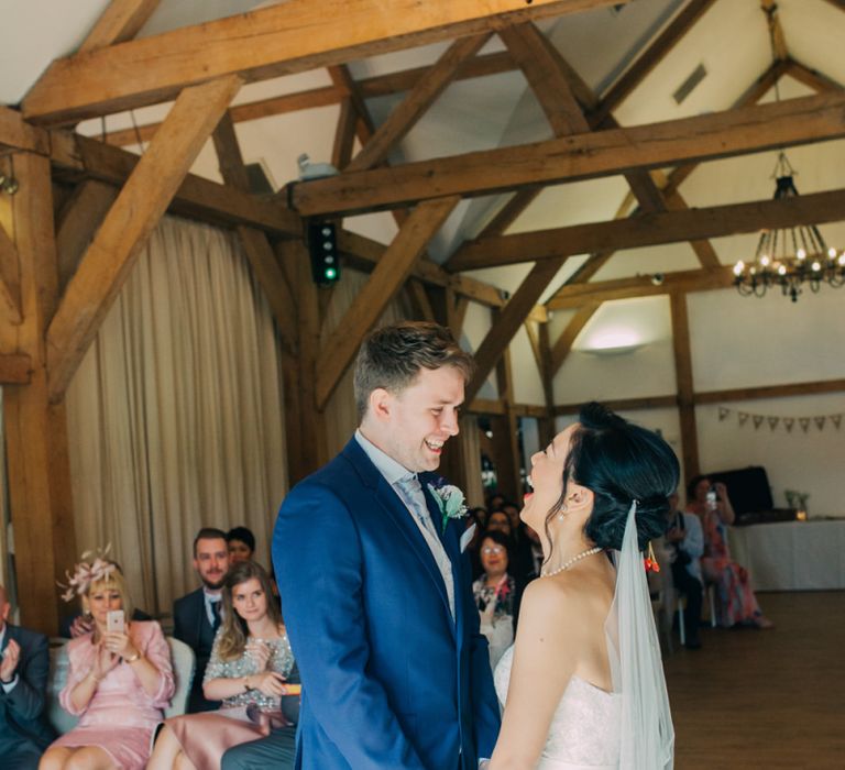 Bride in Princess Wedding Dress and Groom in Navy Suit Exchanging Vows