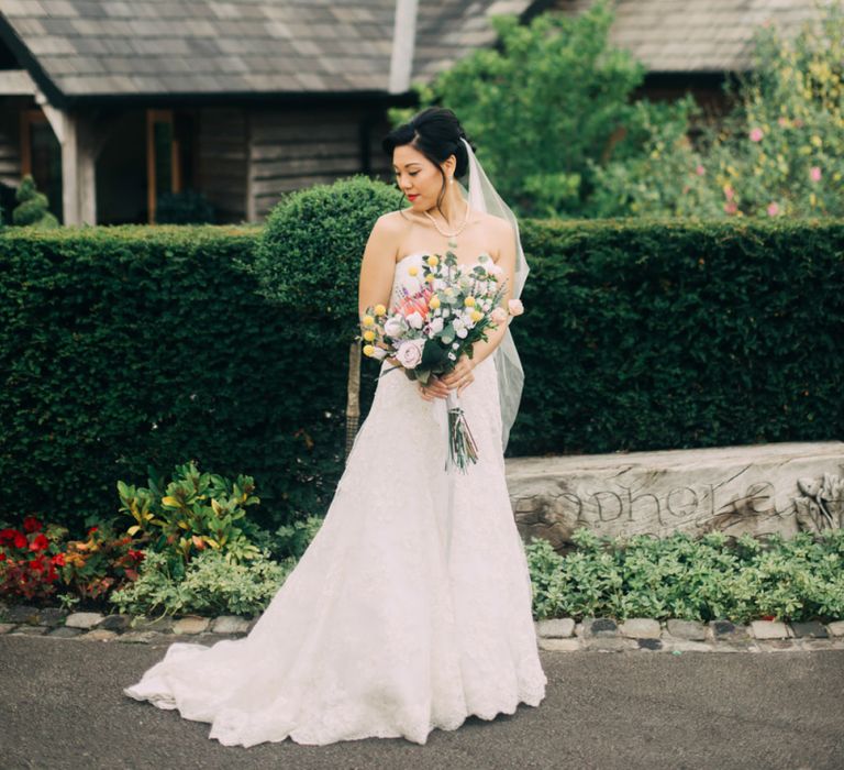 Beautiful Bride in Sweetheart neckline Wedding Dress Holding a Colourful Wedding Bouquet