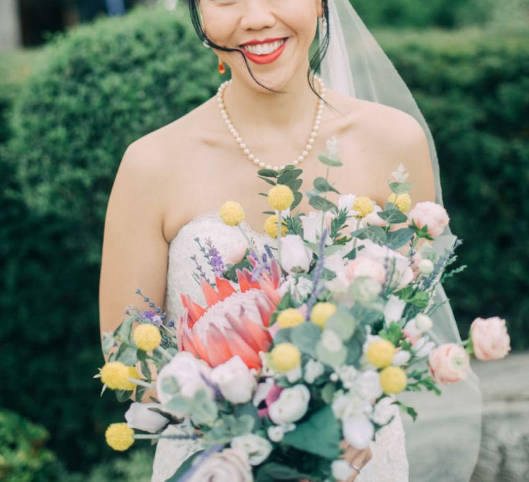 Beautiful Bride in Sweetheart neckline Wedding Dress Holding a Colourful Wedding Bouquet