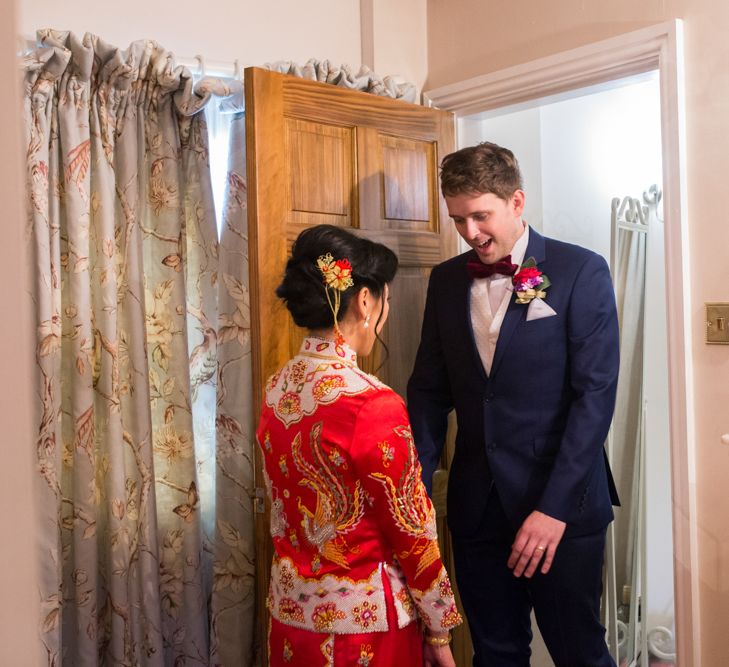 Bride in Red Chinese Wedding Dress Opening Door to Husband-to-be in Tuxedo