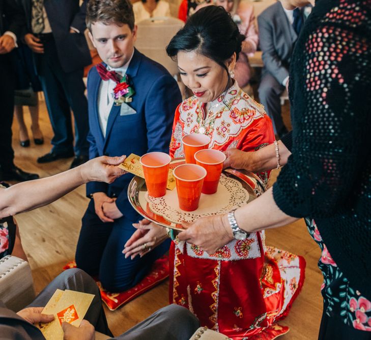 Chinese Tea ceremony with bride in red Chinese wedding dress and groom in tuxedo