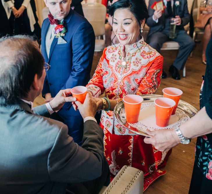 Chinese Tea ceremony with bride in red Chinese wedding dress and groom in tuxedo