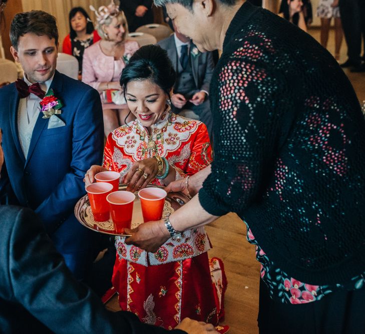 Chinese Tea ceremony with bride in red Chinese wedding dress and groom in tuxedo