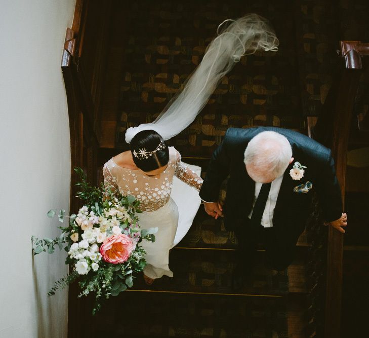 Bride in Applique Rime Arodaky Long Sleeve Wedding Dress Walking Down the Stairs at Cowley Manor