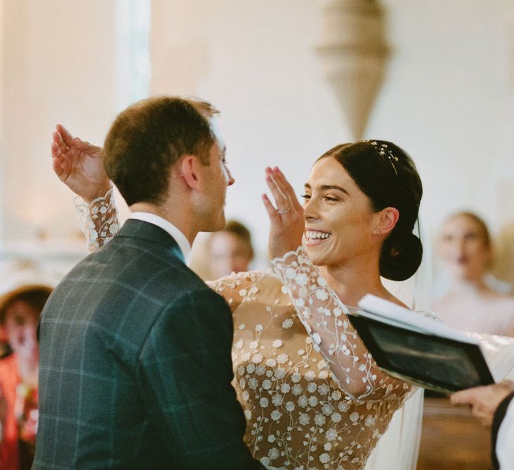 Wedding Ceremony with Bride Laughing in Applique Rime Arodaky Long Sleeve Wedding Dress and Groom in Checked Suit