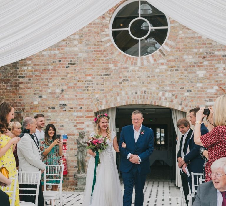 Bride walks up the aisle at conservatory wedding venue