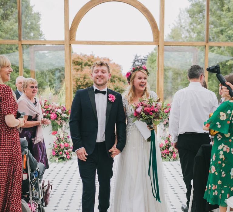 Bride and groom walk down the aisle