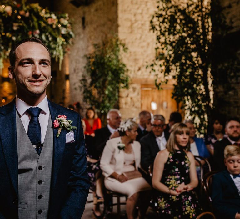 Groom Standing at the Altar  in a Navy Suit with Grey Waistcoat