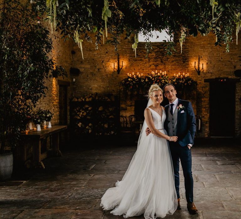 Bride in Stella York Wedding Dress with Tulle Skirt and Groom in Navy Wedding Suit