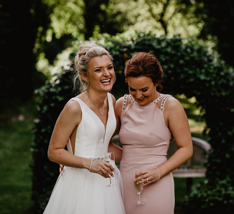 Bride in Stella York Wedding Dress and Bridesmaid in Baby Pink TFNC Dress