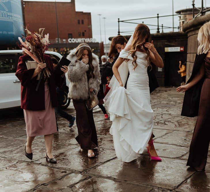 Bride in her bespoke gown and statement shoes with brown bridesmaid dresses and dried flower bouquets