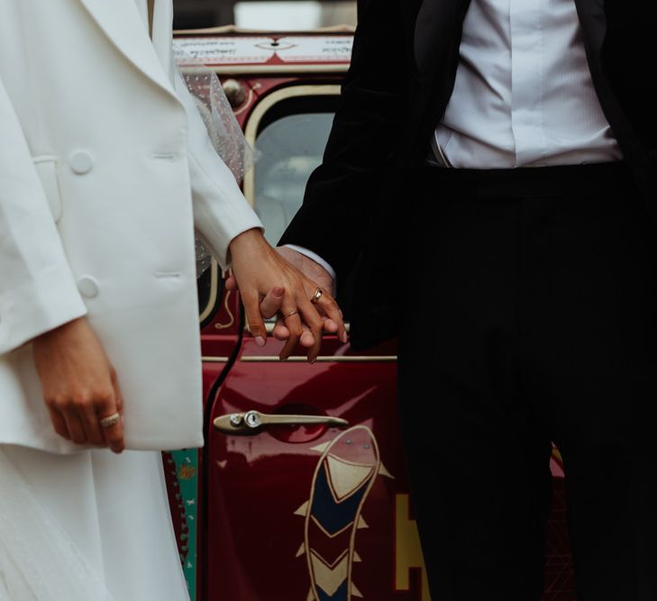 Bride and groom arrive at their reception with personalised Mini Cooper and a statement white bridal blazer