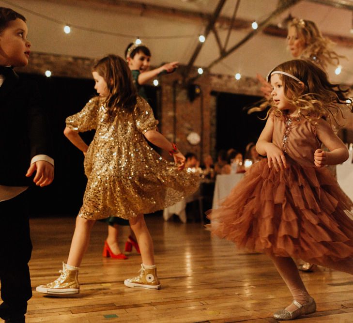 Younger guests enjoying the music at this informal party wedding with festoon lighting and brown bridesmaid dresses