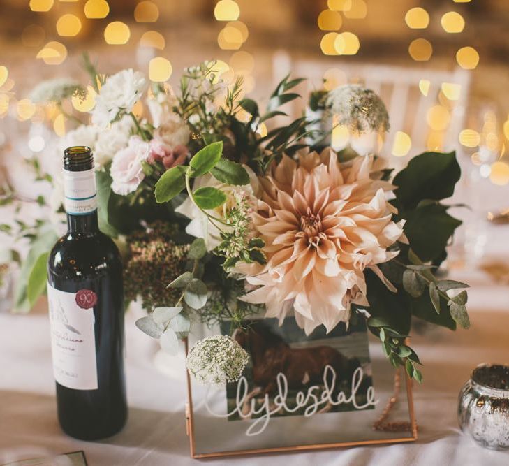 Wedding table flowers in blush to match bridal party in pale blue bridesmaid dresses and blush bouquets