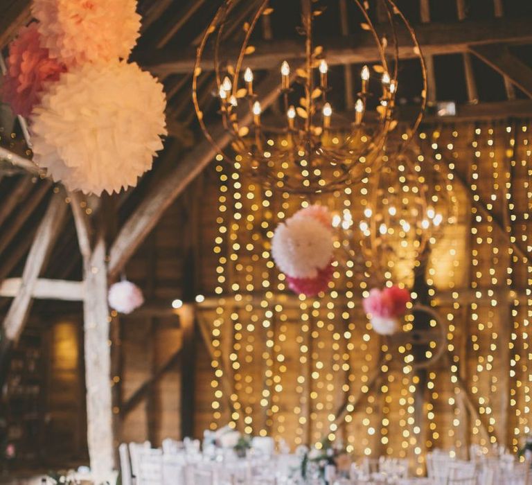 Pink pom pom decorations with fairy light backdrop