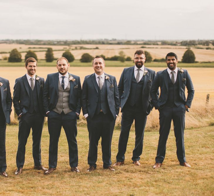 Groomsmen in navy suits with bridal party in pale blue bridesmaid dresses