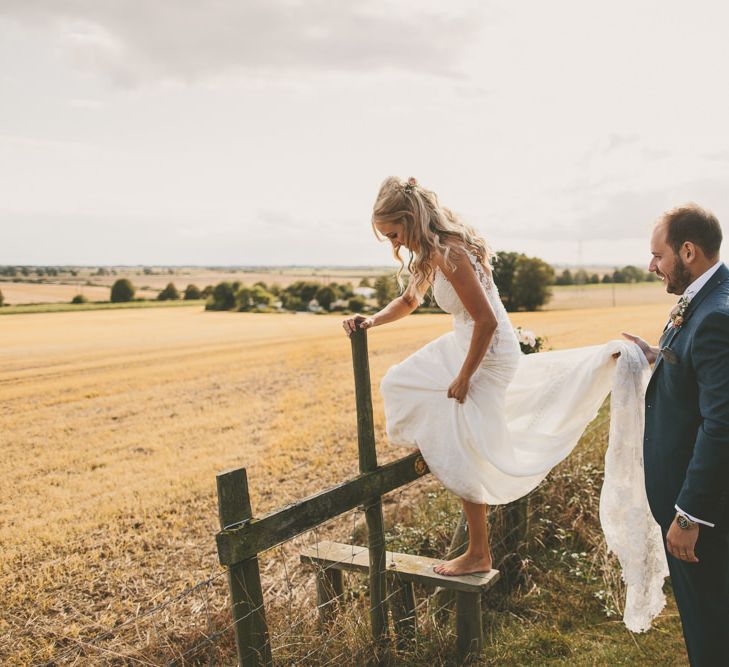 Groom helps bride with her Martina Liana wedding dress