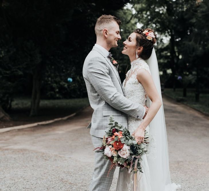 Bride and Groom Embrace with Bright Flowers and Veil