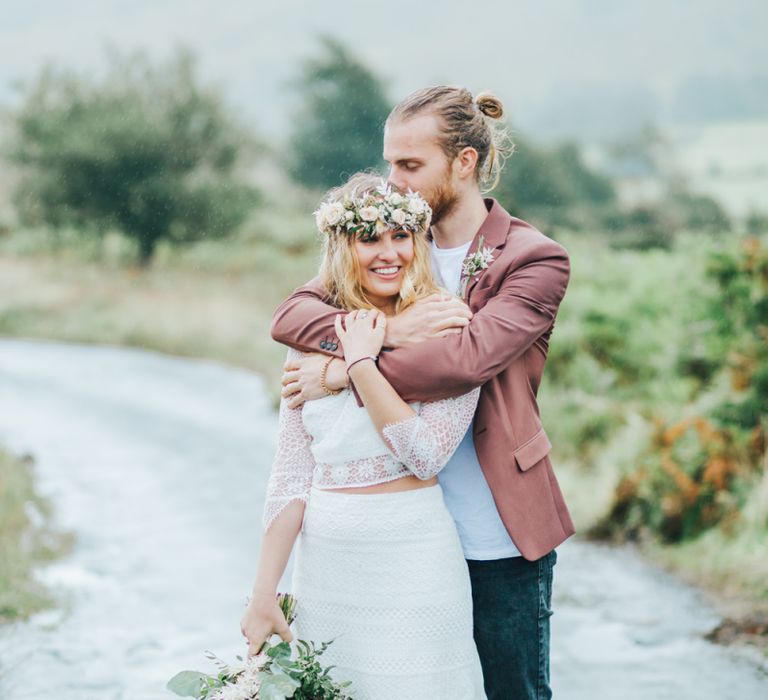 Groom in Pink Jacket Embracing His Boho Bride