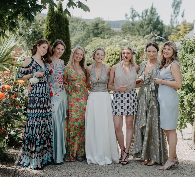 Bride in Embellished Gold Halterneck Top and Satin Skirt with Wedding Guests in Pretty Dresses