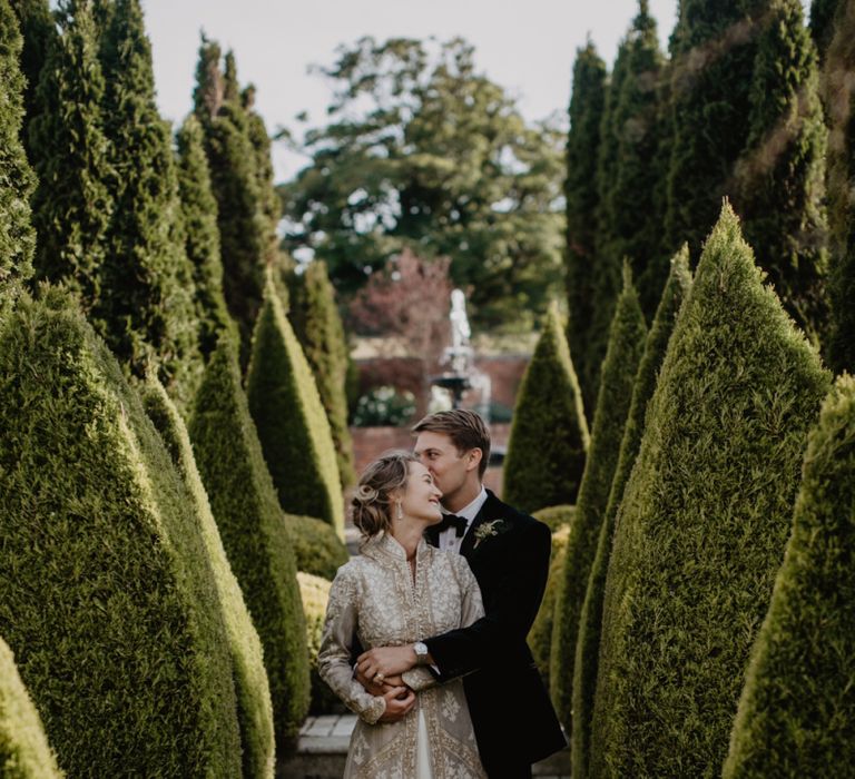 Bride in Gold Embroidered Coat and Groom in Tuxedo and Bow Tie