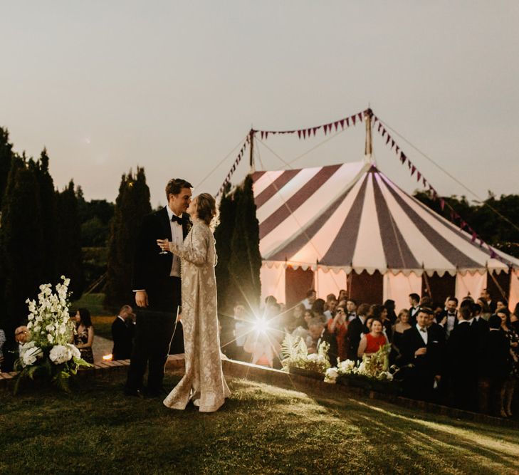 Bride and Groom Kiss In front Of Marquee Reception