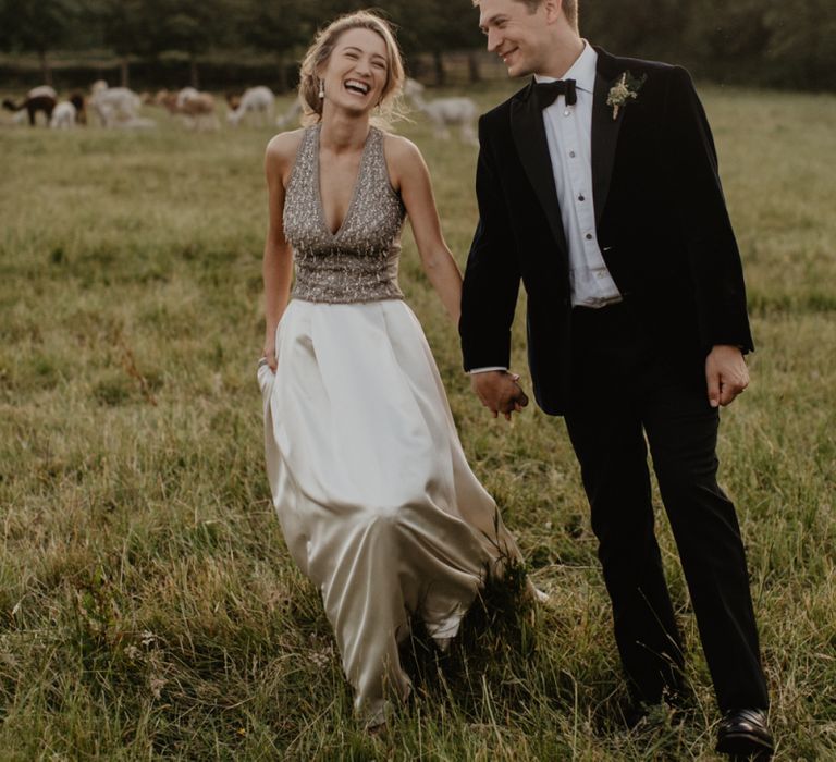 Bride in Halterneck Top and Satin Skirt Bridal Separates and Groom in Tuxedo Laughing Holding Hands