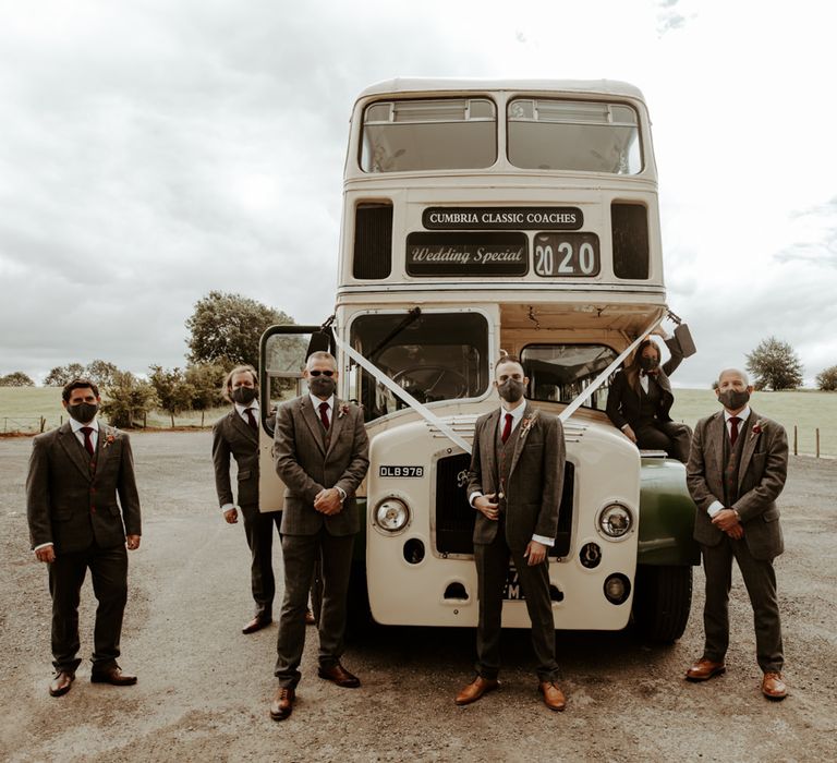 Groomsmen portrait standing in front of a vintage double decker at Eden Barn