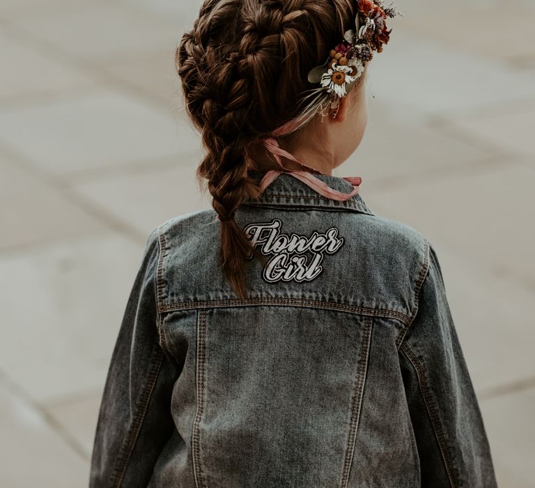 Flower girl with braided up do and customised denim jacket