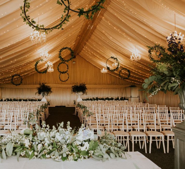 Hoop wedding decor at marquee ceremony with wooden wedding signs